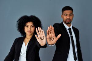 Shot of businessman and businesswoman advocating for gender equality against a grey studio background