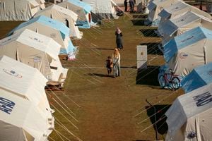La gente camina en un campamento de tiendas de campaña instalado para los sobrevivientes en Adiyaman, en el sur de Turquía, el lunes 13 de febrero de 2023.(AP Photo/Emrah Gurel)