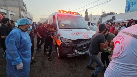 Los palestinos comprueban los daños de un convoy de ambulancias.
