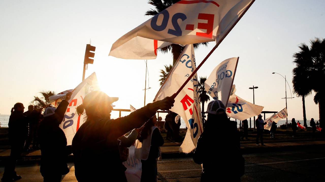 Los manifestantes sostienen banderas y pancartas mientras se reúnen durante una campaña, en Valparaíso, antes de las elecciones para una nueva Constitución.