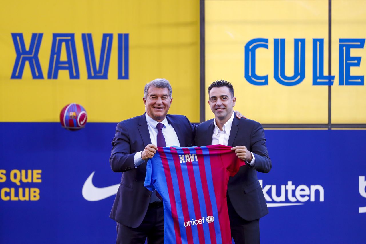 FC Barcelona's new signing coach Xavi Hernandez, right, poses next to FC Barcelona president Joan Laporta during his official presentation at the Camp Nou stadium in Barcelona, Spain, Monday, Nov. 8, 2021. Xavi, who thrived in Barcelona's midfield alongside Messi and Andres Iniesta, was officially introduced as coach on the field of the Camp Nou with a reception usually only offered to top players. (AP Photo/Joan Monfort)
