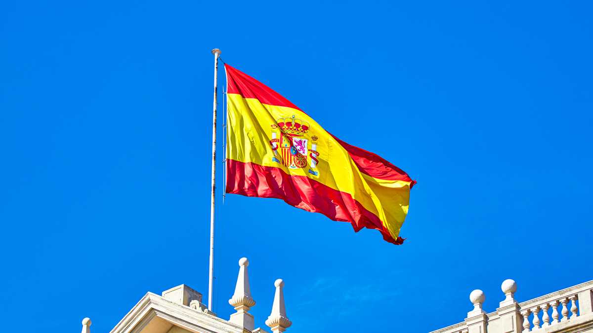 The Spanish flag flying on top of building roof, Spain.