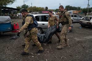 Militares ucranianos cargan una bolsa con el cuerpo de una persona después de un ataque ruso en Zaporizhzhia, Ucrania, el viernes 30 de septiembre de 2022. 