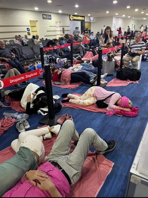 Los viajeros se encuentran durmiendo en el piso a la espera de alguna información.