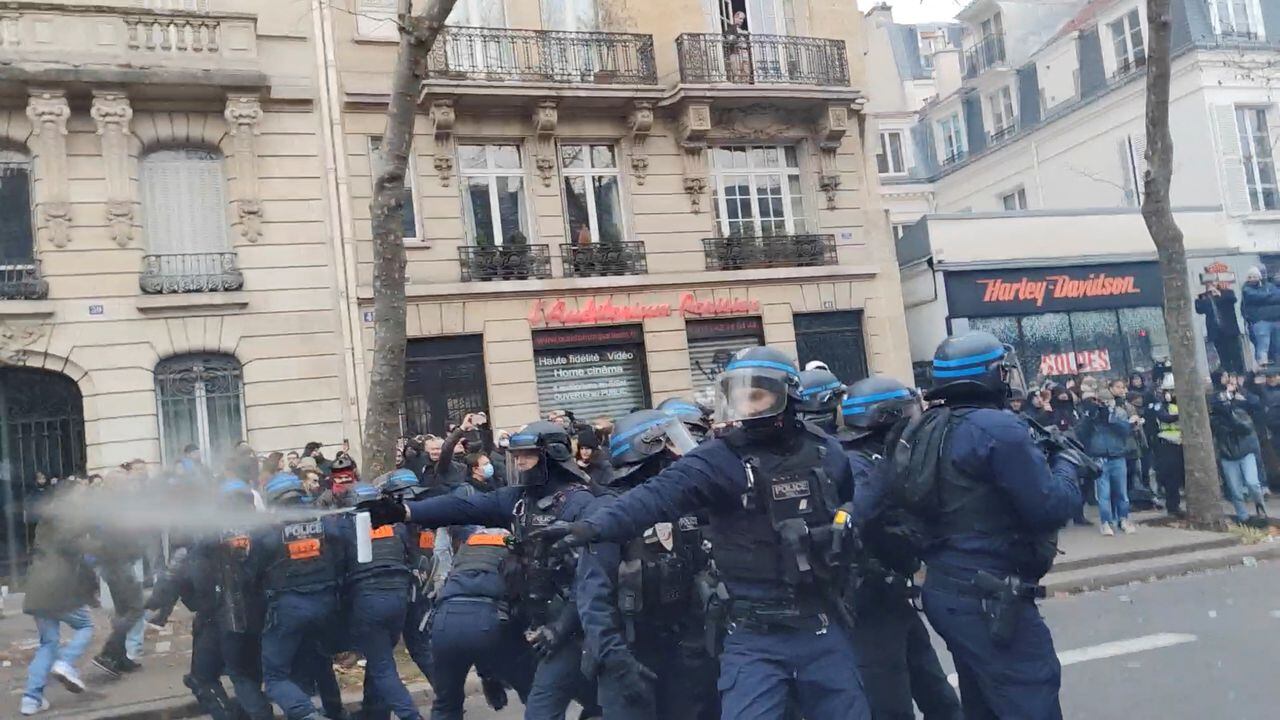 Un oficial de policía rocía a los manifestantes mientras protestan contra el plan de reforma de pensiones del gobierno francés.