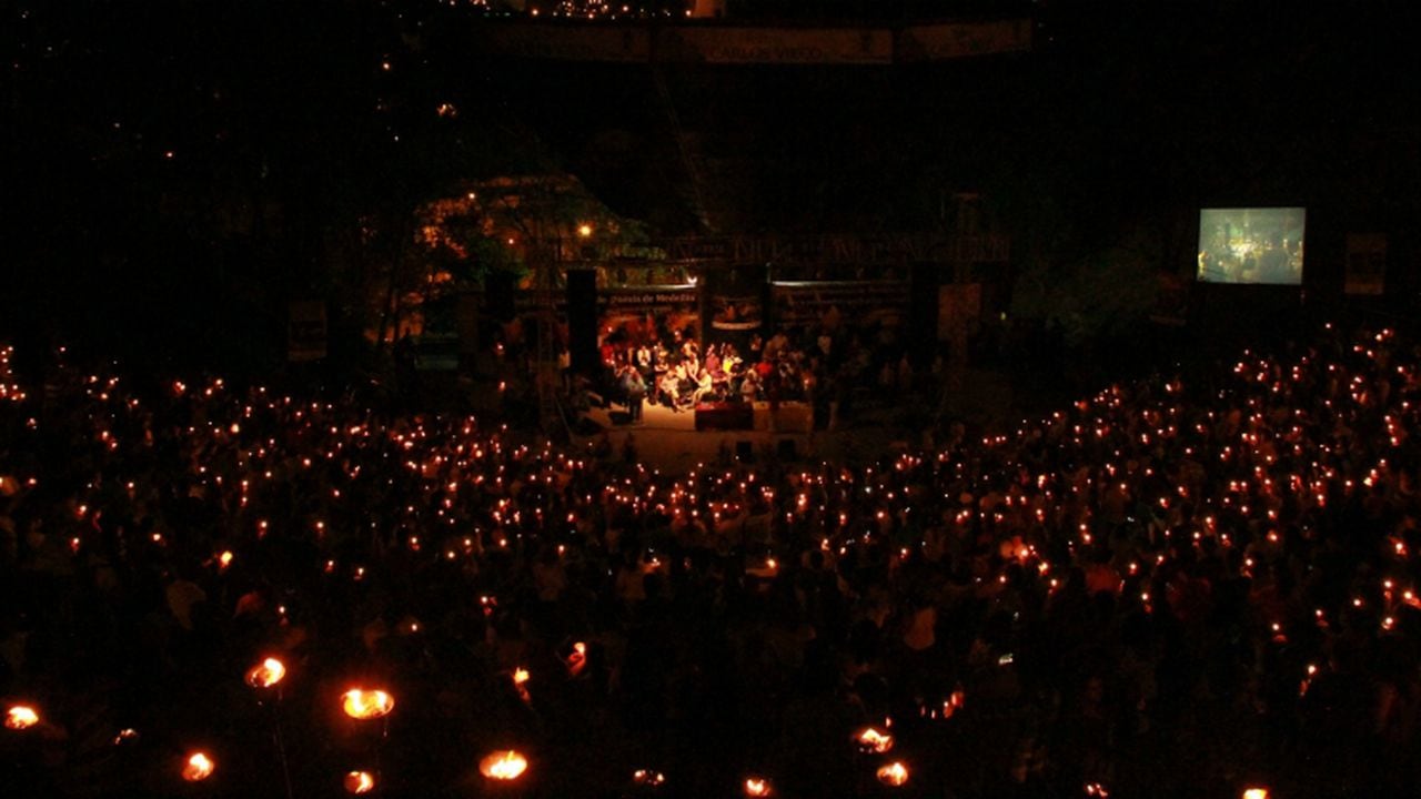 Foto de la clausura del Festival de Poesía de Medellín. Mucha gente con velas oyendo poesía