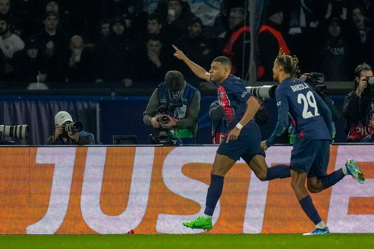 PSG's Kylian Mbappe, left, celebrates with PSG's Bradley Barcola after scoring his side's opening goal during the Champions League round of 16 first leg soccer match between Paris Saint-Germain and Real Sociedad, at the Parc des Princes stadium in Paris, France, Wednesday, Feb. 14, 2024. (AP Photo/Christophe Ena)
