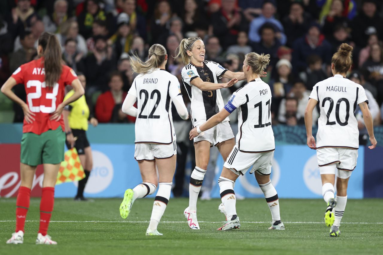 Germany's Kathrin Hendrich, centre left, reaches out to celebrate with teammate Alexandra Popp after she scored the opening goal during the Women's World Cup Group H soccer match between Germany and Morocco in Melbourne, Australia, Monday, July 24, 2023. (AP Photo/Victoria Adkins)