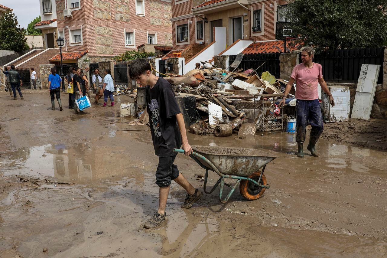 Los residentes ayudan a limpiar el barro y el agua de las casas luego de las fuertes lluvias el 4 de septiembre de 2023 en Villamanta, en la región de Madrid, España.