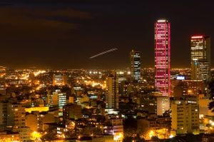 "looking at downtown bogota, colombia and its torre colpatria (on of latin americas talles buildings) that is illuminated in different colors, see more colors in my portfolioNotice the plane taking off in the center of the frame!"
