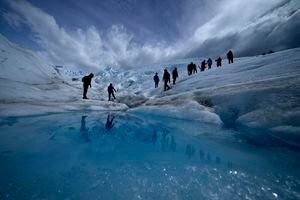 Turistas caminan sobre el glaciar Perito Moreno en el Parque Nacional Los Glaciares, cerca de El Calafate, Argentina, el martes 2 de noviembre de 2021. Los líderes mundiales se reúnen en Escocia en una cumbre climática de las Naciones Unidas, conocida como COP26, para impulsar a las naciones a aumentar sus esfuerzos para frenar el cambio climático. Los expertos dicen que la cantidad de energía desatada por el calentamiento planetario podría derretir gran parte del hielo del planeta, elevar el nivel global del mar y aumentar los eventos climáticos extremos. (Foto AP / Natacha Pisarenko)