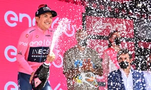 Ecuador's cyclist Richard Carapaz celebrates on the podium after after earning the overall leader's pink jersey of the Giro D'Italia cycling race from Santena to Turin, Italy, Saturday, May 21, 2022. (Massimo PaoloneLaPresse via AP)