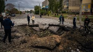 Los residentes locales examinan un cráter luego de un ataque con misiles en Dnipro el 10 de octubre de 2022, en medio de la invasión rusa de Ucrania.