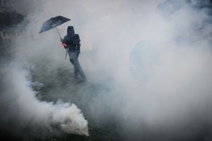 Un manifestante se para en nubes de gases lacrimógenos en medio de enfrentamientos con la policía antidisturbios durante una manifestación el Primero de Mayo (Día del Trabajo), para conmemorar el día internacional de los trabajadores, más de un mes después de que el gobierno aprobara una impopular ley de reforma de las pensiones en el parlamento, en Nantes. , noroeste de Francia, el 1 de mayo de 2023. - Los partidos de oposición y los sindicatos han instado a los manifestantes a mantener su campaña de tres meses contra la ley que aumentará la edad de jubilación de 62 a 64. (Foto de LOIC VENANCE / AFP)