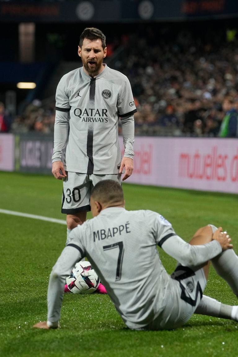 PSG's Lionel Messi stands next to injured PSG's Kylian Mbappe during the French League One soccer match between Montpellier and Paris Saint-Germain at the State La Mosson stadium in Montpellier, France, Wednesday, Feb. 1, 2023. (AP Photo/Thibault Camus)
