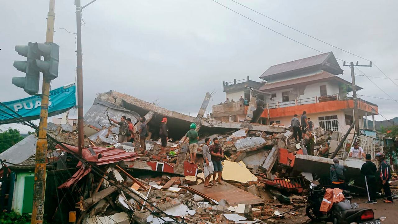 Los residentes inspeccionan los edificios dañados por el terremoto en Mamuju, West Sulawesi, Indonesia.