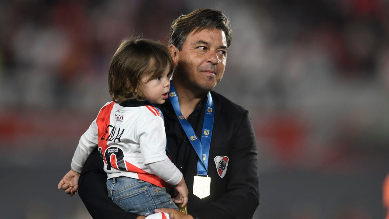 River Plate coach Marcelo Gallardo holds his sone Benjamin as he celebrates winning the local soccer tournament at the Monumental in Buenos Aires, Argentina Thursday, Nov. 25, 2021. River defeated Racing 4-0 and became the tournament champions. (AP Photo/Gustavo Garello)