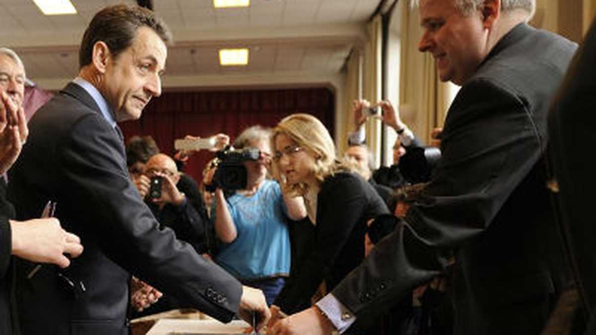 El presidente francés en funciones y candidato por el partido UMP, Nicolas Sarkozy (izq), ejerce su derecho al voto en un colegio electoral de Paris (Francia) durante la primera vuelta de las elecciones presidenciales francesas.