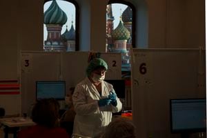 Una trabajadora médica prepara una dosis de la vacuna rusa contra el COVID-19 Sputnik Lite, en un centro de vacunación en una tienda GUM, en la Plaza Roja, con la catedral de San Basilio al fondo, en Moscú, Rusia, el 26 de octubre de 2021. (AP Foto/Pavel Golovkin)