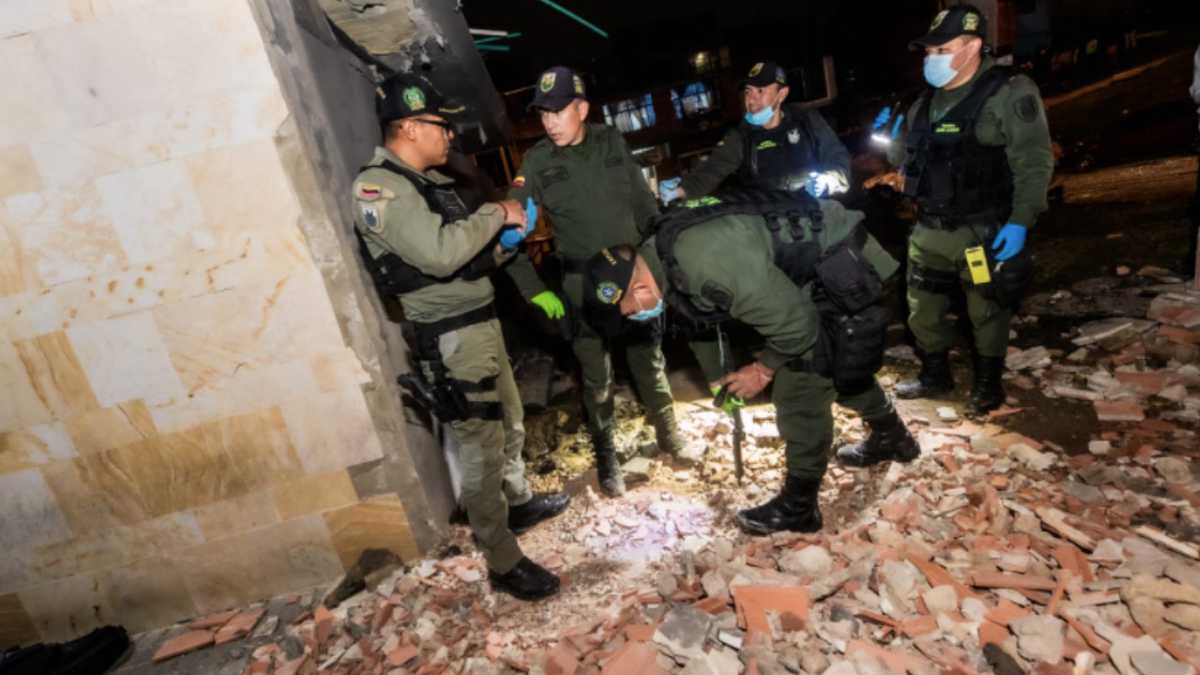 Varios policías realizan labores de investigación y de levantamiento de escombros en el lugar afectado
