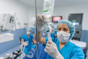 Doctor en el quirófano colocando medicamentos a través de una vía intravenosa