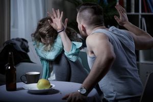 Hombre agresivo gritando golpeando a su esposa asustada
