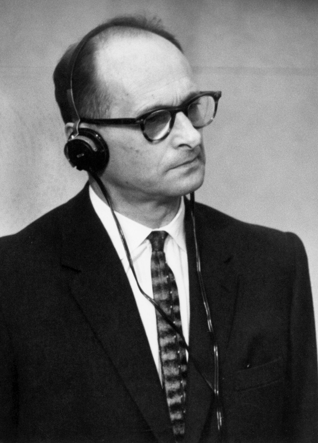 ISRAEL - 17 DE DICIEMBRE: Adolf Eichmann, en una cabina a prueba de balas, se pone los auriculares para escuchar la lectura del acto de acusación en su contra. A la izquierda está su abogado alemán Servatius. Eichmann, un burócrata nazi alemán, fue el primero a cargo de la exterminación el 17 de diciembre de 1961. (Foto de Keystone-France/Gamma-Keystone a través de Getty Images)