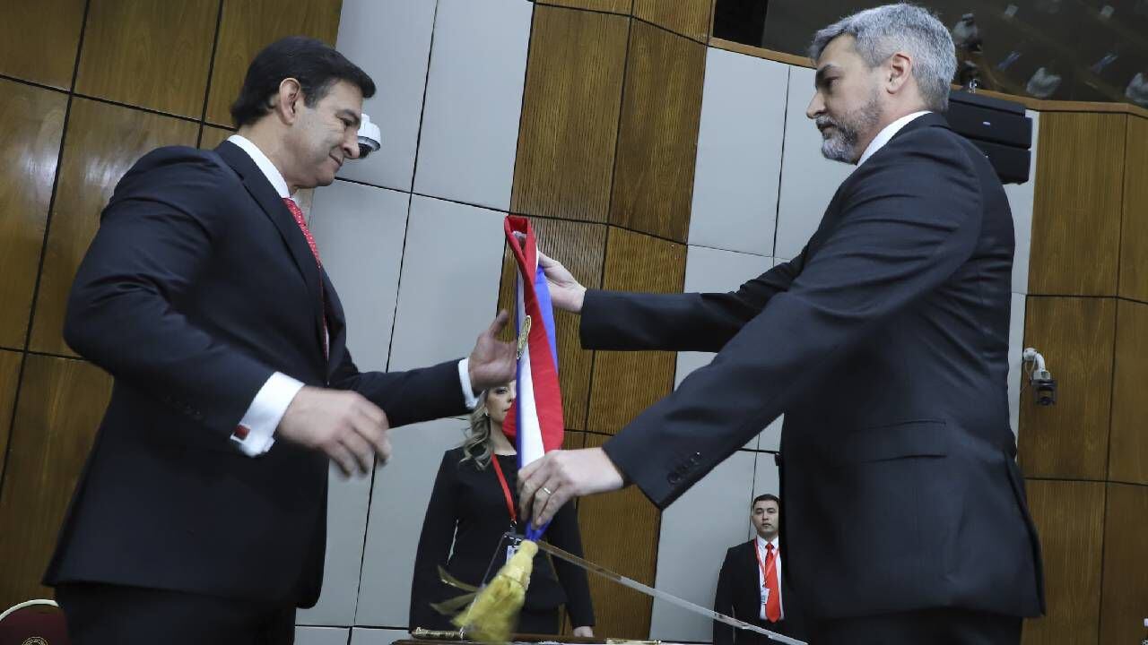 El expresidente paraguayo Mario Abdo Benítez, a la derecha, entrega la banda presidencial al presidente del Congreso, Silvio Ovelar.