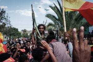 Mujeres soldados de la Fuerza de Defensa de Tigray (TDF) celebran sentadas sobre los hombros de los hombres mientras la gente celebra su regreso en una calle en Mekele, la capital de la región de Tigray, Etiopía, el 29 de junio de 2021. - Combatientes rebeldes en Tigray, golpeado por la guerra en Etiopía, incautaron control de más territorio el 29 de junio de 2021, un día después de retomar la capital local y prometer expulsar a todos los "enemigos" de la región. (Foto de Yasuyoshi Chiba / AFP)