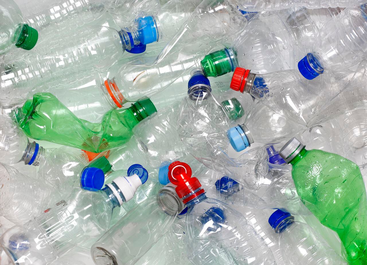 botellas de agua usadas desechadas en la papelera de reciclaje. Las tapas también se pueden reciclar si se vuelven a colocar en la botella de agua.