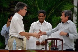 The head of the Colombian government delegation for the peace talks with the ELN guerrillas Gustavo Bell (L) and The chief negotiator of Colombia's last rebel group, the National Liberation Army (ELN), Pablo Beltran, shake hands during the sixth round of peace talks in Havana, on August 01, 2018. - Outgoing Colombia president Juan Manuel Santos admitted defeat on Wednesday after failing to secure a ceasefire with ELN Marxist guerrillas before handing over the reins to hardline right-wing successor Ivan Duque next week. (Photo by YAMIL LAGE / AFP)