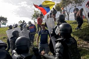 La policía antidisturbios se enfrenta a un manifestante en un bloqueo de carretera en la carretera Ruta Viva, que conduce al aeropuerto Mariscal Sucre, en el marco de protestas lideradas por indígenas contra los altos precios del combustible y el costo de vida, en Quito el 17 de junio de 2022. - Pueblos indígenas, que conforman más de un millón de los 17,7 millones de habitantes de Ecuador, se embarcaron el lunes en una protesta antigubernamental abierta a la que desde entonces se han sumado estudiantes y otros grupos descontentos. (Foto por Cristina Vega RHOR / AFP)