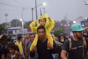Un niño se sienta sobre los hombros de un hombre, mientras los migrantes forman parte de una caravana para cruzar el país y llegar a la frontera con Estados Unidos, mientras los líderes regionales se reúnen en Los Ángeles para discutir la migración y otros temas, en Tapachula, México, el 6 de junio de 2022. Foto REUTERS/ Quetzalli Nicte-Ha