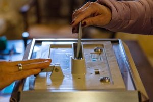 Una mujer emite su voto para la primera ronda de las elecciones presidenciales de Francia en un colegio electoral en el Mont Saint-Michel el 10 de abril de 2022. (Foto de Sameer Al-DOUMY / AFP)