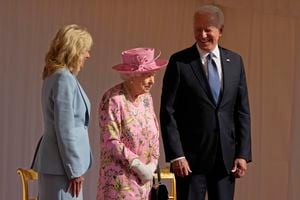 El presidente Joe Biden y la primera dama Jill Biden sonríen mientras están de pie con la reina Isabel II de Gran Bretaña viendo pasar a una Guardia de Honor antes de su reunión en el Castillo de Windsor cerca de Londres, el 13 de junio de 2021.