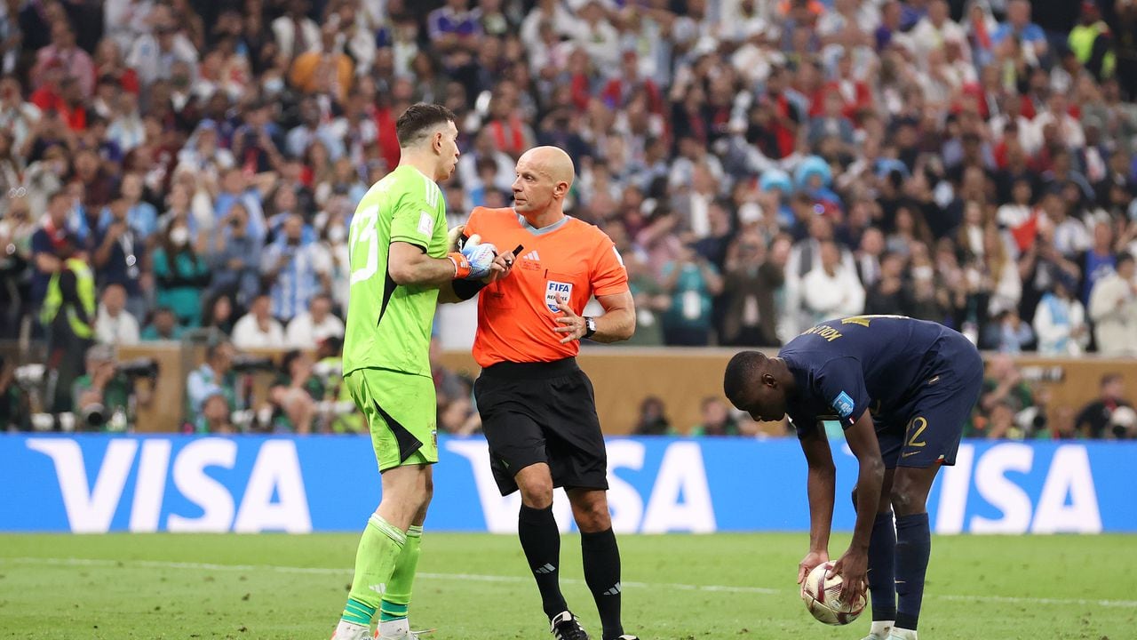 LUSAIL CITY, QATAR - DECEMBER 18: Emiliano Martinez of Argentina is prevented by referee Szymon Marciniak from speaking to Randal Kolo Muani of France in the penalty shootout during the FIFA World Cup Qatar 2022 Final match between Argentina and France at Lusail Stadium on December 18, 2022 in Lusail City, Qatar. (Photo by Julian Finney/Getty Images)
