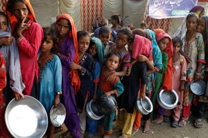 Las víctimas de las inundaciones se reúnen para recibir alimentos en un campamento, luego de las lluvias e inundaciones durante la temporada de monzones en Sehwan, Pakistán, 14 de septiembre de 2022. 