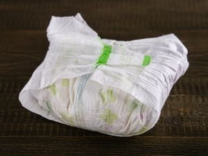 dirty diaper on dark wooden background, selective focus