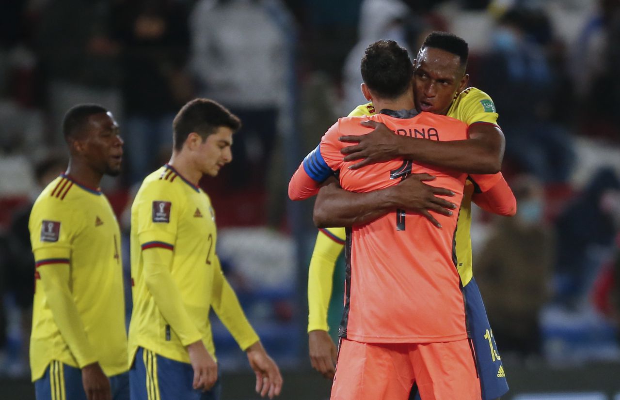Colombia's Yerry Mina, right, embraces goalkeeper David Ospina at the end of a qualifying soccer match for the FIFA World Cup Qatar 2022 against Uruguay in Montevideo, Uruguay, Thursday, Oct. 7, 2021. The game ended in a 0-0 tie. (Andres Cuenca/Pool via AP)