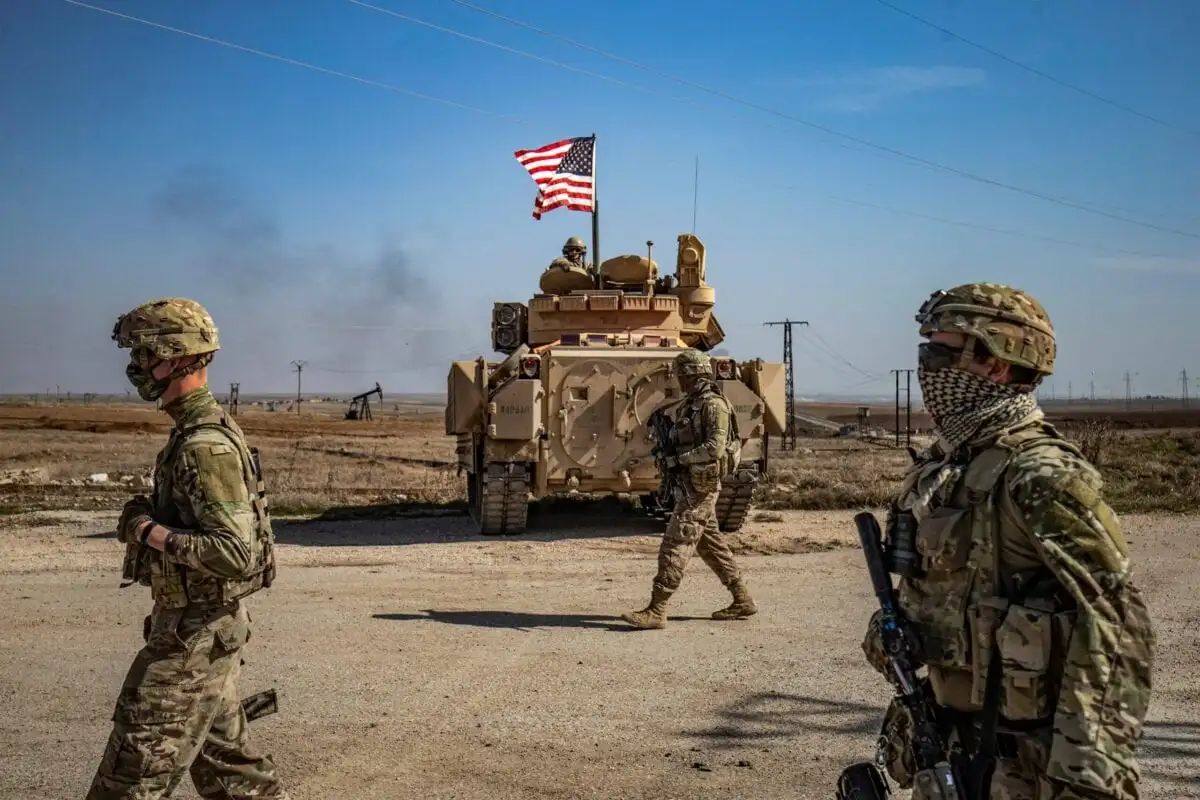 Soldados estadounidenses caminan mientras patrullan junto a los campos petrolíferos de Suwaydiyah, en la provincia nororiental de Hasakah, el 13 de febrero de 2021 [DELIL SOULEIMAN/AFP vía Getty Images].