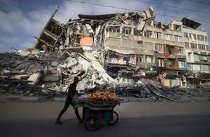 A Palestinian man walks past the destroyed Al-Shuruq building in Gaza City on May 20, 2021 after it was bombed by an Israeli air strike. - Israel and the Palestinians are mired in their worst conflict in years as Israel pounds the Gaza Strip with air strikes and artillery, while Hamas militants fire rockets into the Jewish state. (Photo by MAHMUD HAMS / AFP)