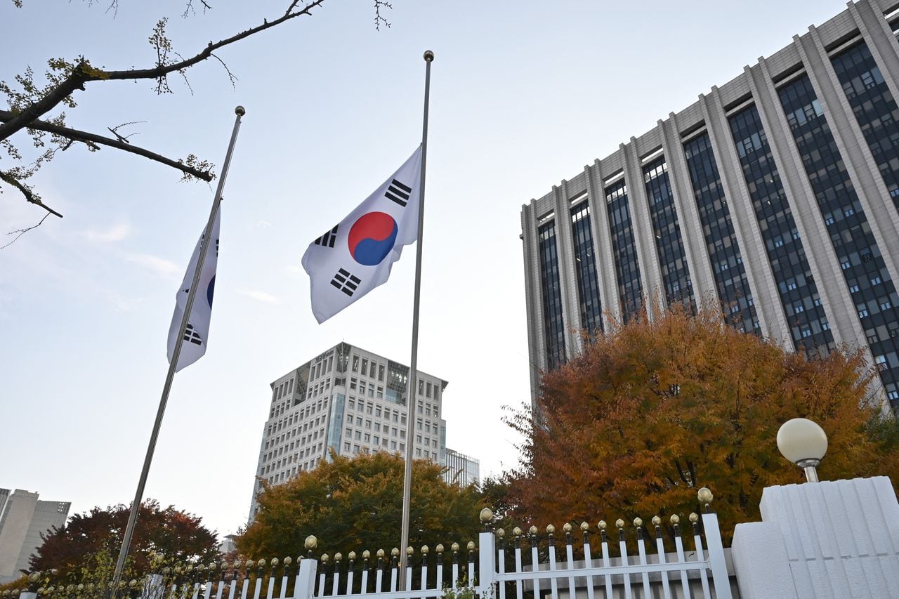 Las banderas nacionales de Corea del Sur ondean a media asta en el complejo gubernamental de Seúl el 30 de octubre de 2022, después de la estampida de Halloween en el popular distrito de Itaewon de la capital. - Más de 150 personas murieron y decenas más resultaron heridas en una estampida en un evento de Halloween repleto en el centro de Seúl a última hora del 29 de octubre, dijeron las autoridades, en uno de los peores accidentes en tiempos de paz de Corea del Sur. (Foto de Jung Yeon-je / AFP)