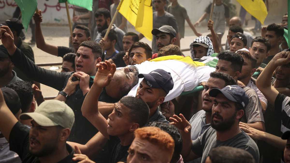 Los dolientes palestinos llevan el cuerpo de Ibrabim Abu Salah, de 45 años de edad, durante su funeral en Beit Hanoun, en el norte de la Franja de Gaza, el 10 de agosto de 2022 después de que una tregua detuviera el conflicto mortal entre el ejército israelí y los militantes de la Yihad Islámica en el enclave costero palestino de Gaza. . (Foto de Mahmud JAMONES / AFP)