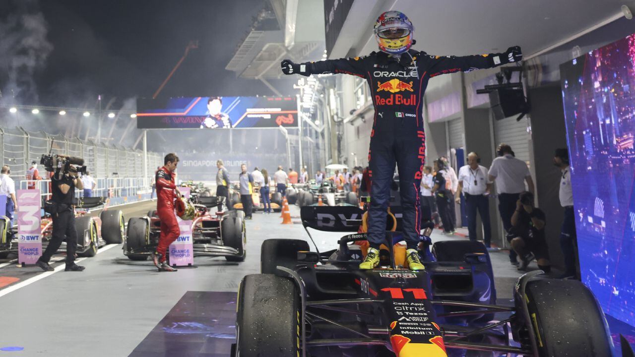 Red Bull driver Sergio Perez of Mexico stands on his car as he celebrate after winning the Singapore Formula One Grand Prix, at the Marina Bay City Circuit in Singapore, Sunday, Oct.2, 2022. (AP/Danial Hakim)