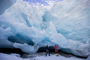 Los glaciólogos Andrea Fischer y Martin Stocker-Waldhuber, de la Academia de Ciencias de Austria, inspeccionan la entrada de una cavidad glaciar natural del glaciar Jamtalferner cerca de Galtuer, Austria, el 15 de octubre de 2021. Foto REUTERS / Lisi Niesner 