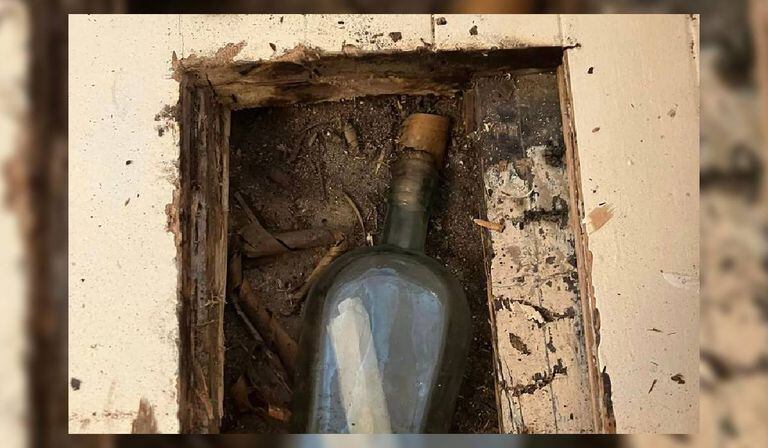 Se trataba de una botella de whisky vacía que estaba escondida bajo el suelo de la casa y dentro del envase se encontraba una antigua nota