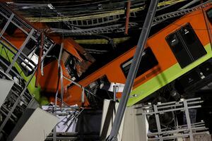 Mexico City's subway cars lay at an angle after a section of Line 12 of the subway collapsed in Mexico City, Tuesday, May 4, 2021. The section passing over a road in southern Mexico City collapsed Monday night, dropping a subway train, trapping cars, and causing at least 50 injuries and several dead, authorities said. (AP Photo/Marco Ugarte)