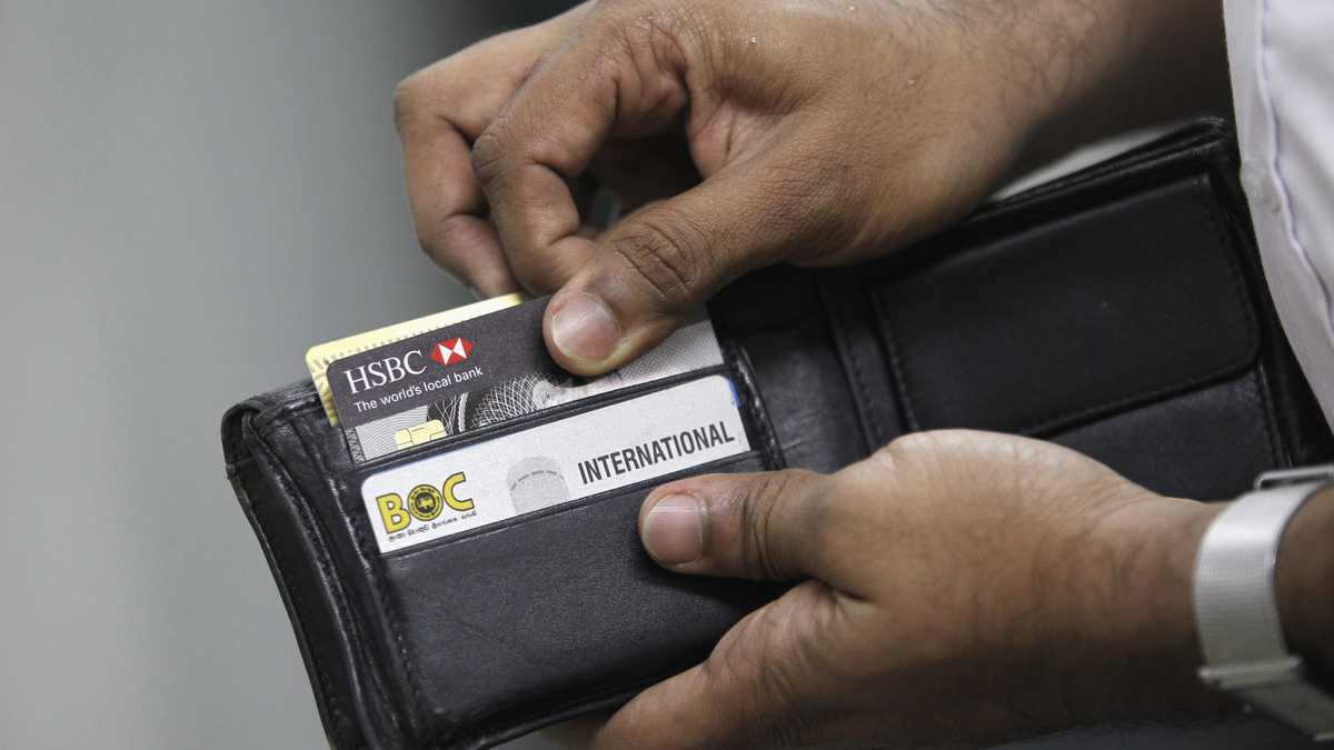 Un hombre saca su tarjeta de crédito para hacer una compra en una tienda. REUTERS / Dinuka Liyanawatte (SRI LANKA - Etiquetas: NEGOCIOS)