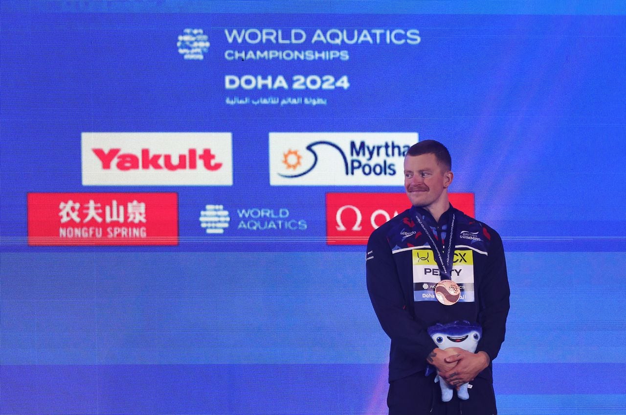 Adam Peaty, del equipo de Gran Bretaña, celebra en el podio su medalla de bronce en los 100 metros braza masculinos durante la undécima jornada de los Campeonatos Mundiales Acuáticos de Doha 2024 en el Aspire Dome el 12 de febrero de 2024 en Doha, Qatar.