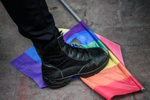 In this file photo taken on June 19, 2016 a Turkish anti-riot police officer steps on a rainbow flag during a rally staged by the LGBT community on Istiklal avenue in Istanbul. - LGBT associations denounce a "hate campaign" by Turkish President aimed at making his conservative voters forget the economic problems, at the risk of encouraging violence against a particularly vulnerable community. (Photo by OZAN KOSE / AFP)
